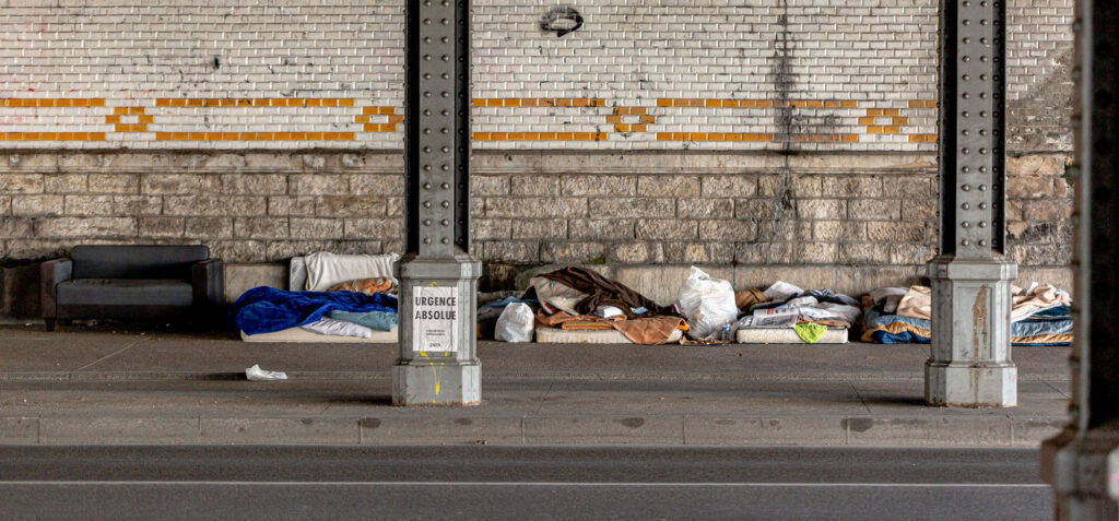 A small homeless encampment under a bridge